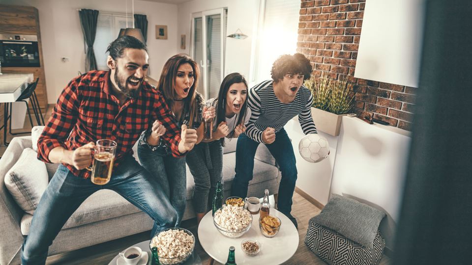 Amigos entusiasmados a ver um jogo de futebol
