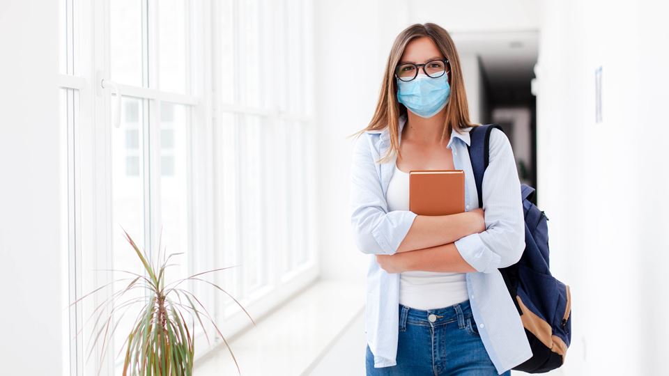Rapariga na universidade com máscara Rapariga na universidade com máscara